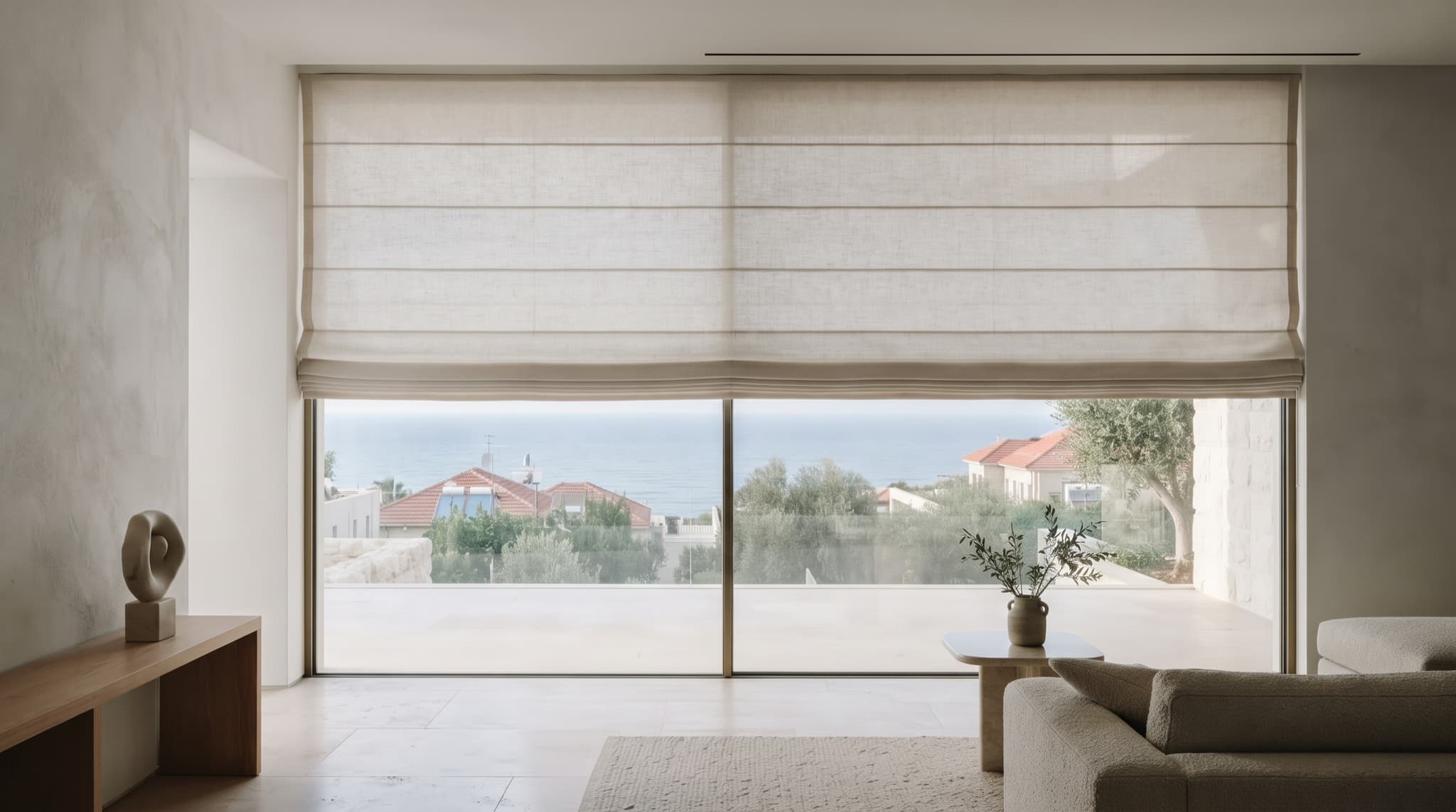 וילון רומאי מבד פשתן בהיר בחלון סלון רחב, עם נוף לים
